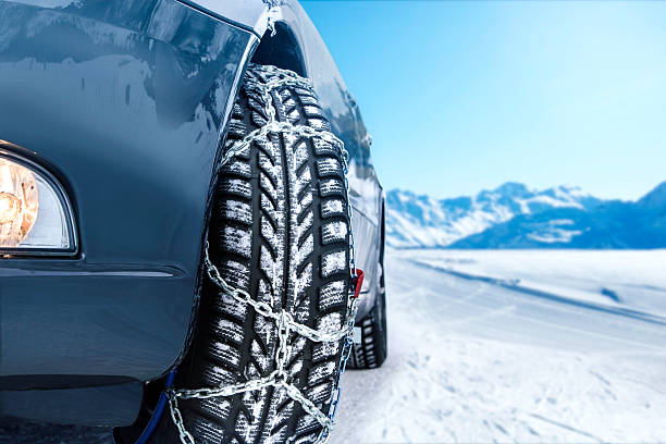 Car with mounted snow chains Car with mounted snow chains in wintry environment vehicle accessory stock pictures, royalty-free photos & images