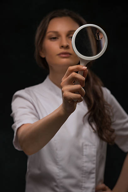 医師から見た拡大鏡 - low scale magnification glass women holding ストックフォトと画像