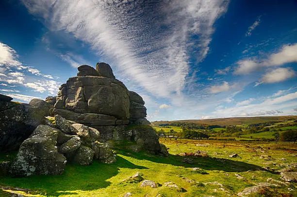 Houndtor in Datrmoor, Devon, UK on a sunny day with cirrus clouds.