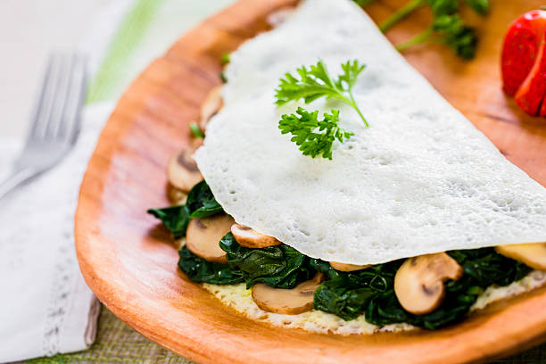 Egg White Omelet with Spinach and Mushrooms An egg-white omelet with sautéed spinach and sliced mushrooms. egg white stock pictures, royalty-free photos & images