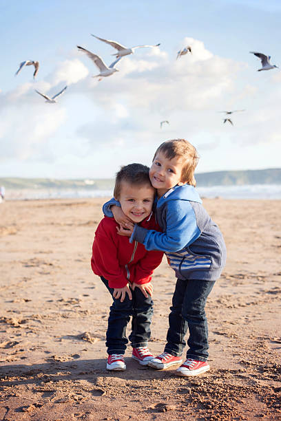 istock Two adorable kids on the beach, seagulls flying around 466681190
