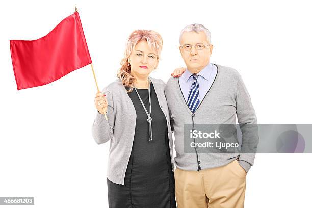 Photo libre de droit de Milieu Couple Âgé Agitant Un Drapeau Rouge banque d'images et plus d'images libres de droit de Adulte - Adulte, Adulte d'âge mûr, Blanc