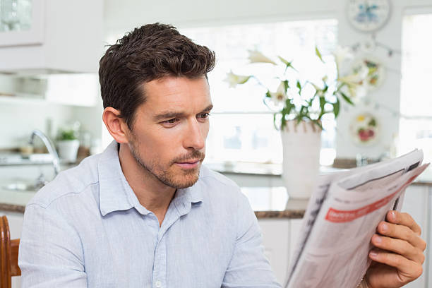 istock Man reading newspaper at home 466684580