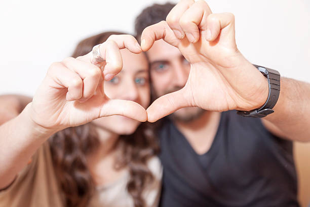 istock pretty young couple makes heart sign with his hands 466687326