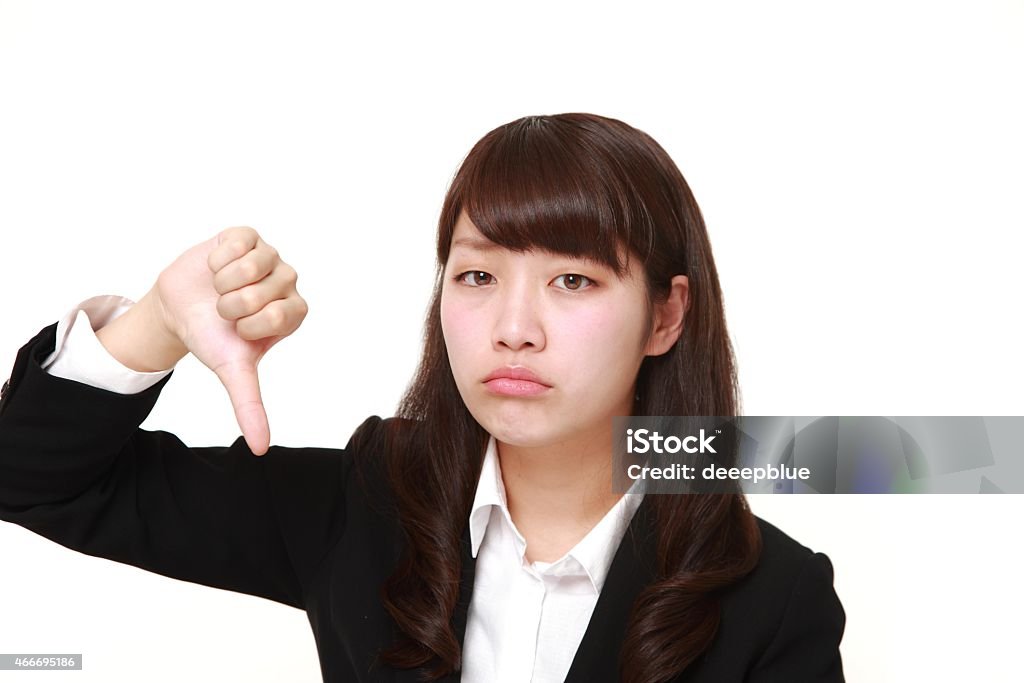 businesswoman with thumbs down gesture young Japanese businesswoman with thumbs down gesture on white background 20-29 Years Stock Photo