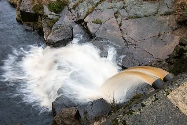 Overflow chute with runningh water from a small dam built to catch the water of a moorland stream.