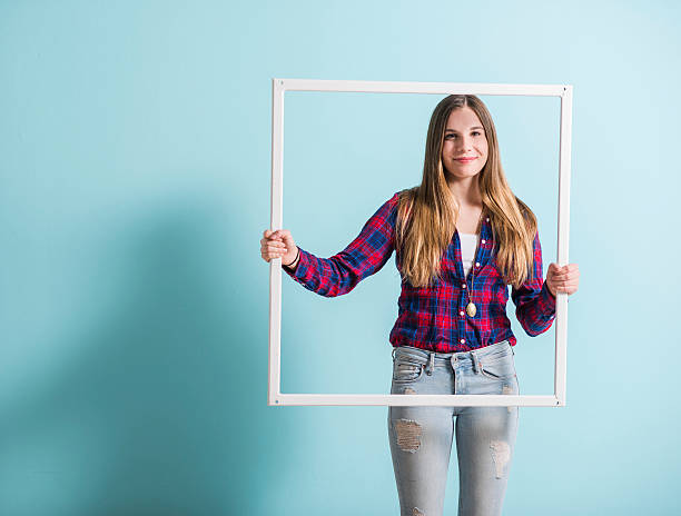 istock Young girl looking through picture frame 466696498