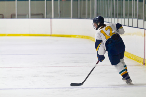Female ice hockey player skating during a game
