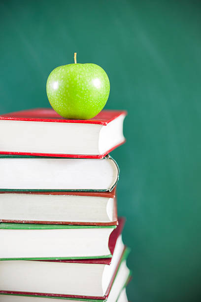 istock Back to school:Green apple  sitting on education books 466703896
