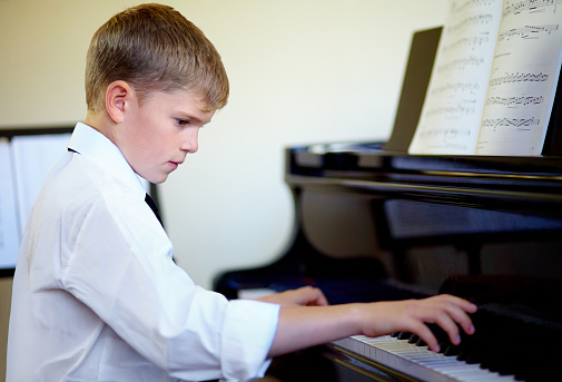 Little boy having fun practicing piano.