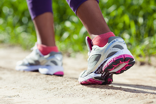 Close-up of women's sport shoes running outdoors. Focus on forward.