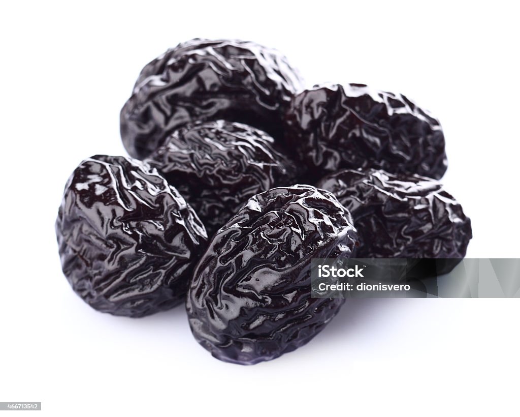 Several dried prunes on a white background Dried prune in closeup Dried Plum Stock Photo