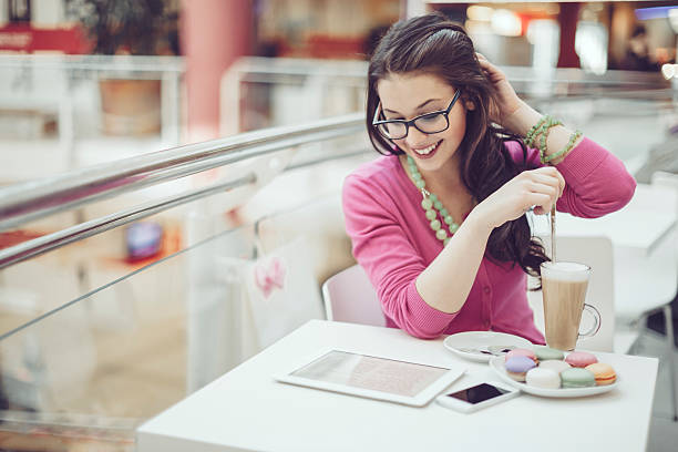 Young woman reading her tablet in a coffee shop