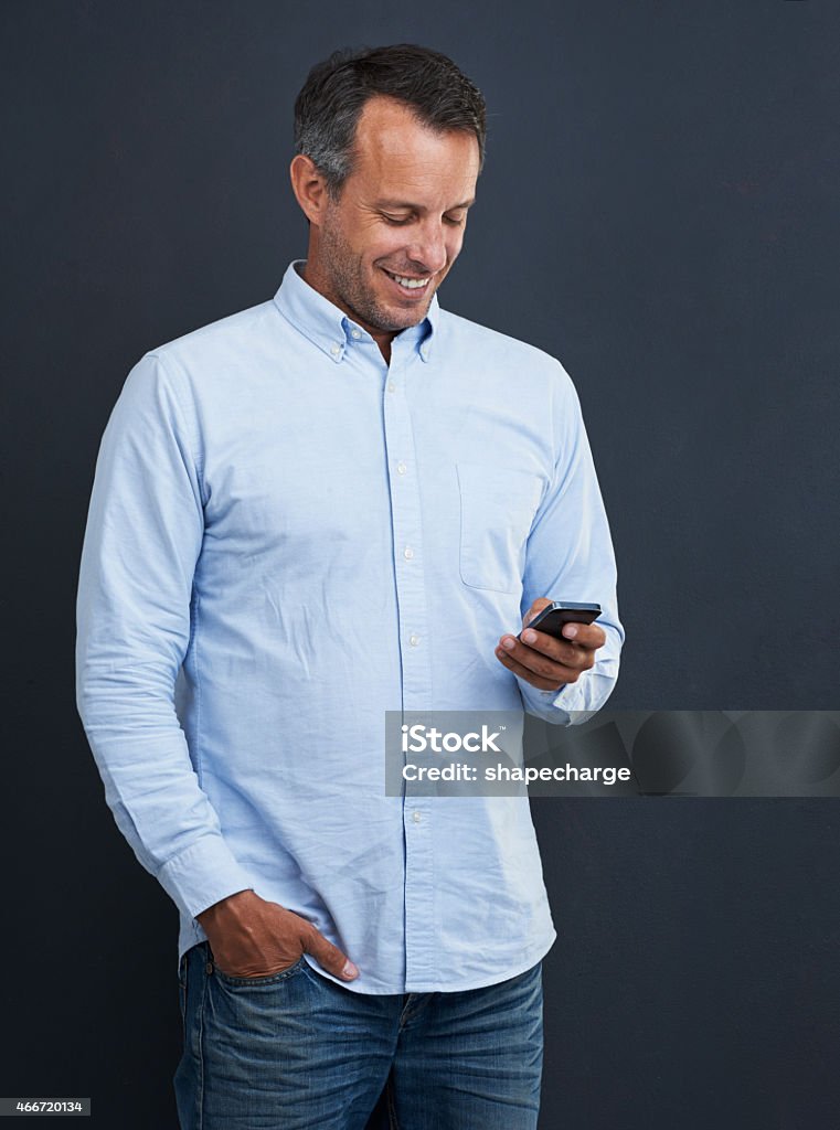 Text: Had a great time yesterday! Studio shot of a handsome mature man using his cellphone against a gray backgroundhttp://195.154.178.81/DATA/istock_collage/a3/shoots/785270.jpg 2015 Stock Photo