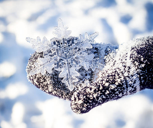 istock big snowflake in hands on dark mittens on winter background 466724540