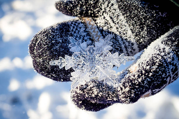 istock big snowflake in hands on dark mittens on winter background 466724542