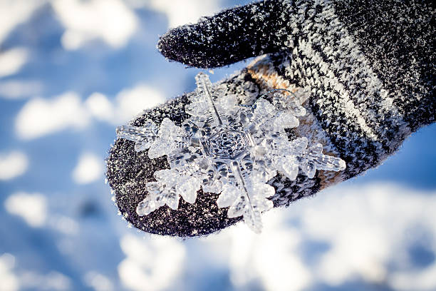 istock big snowflake in hands on dark mittens on winter background 466724548
