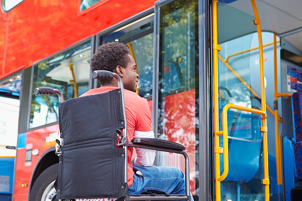 Disabled Man In Wheelchair Boarding Bus Disabled African American Man In Wheelchair Boarding Bus public transportation stock pictures, royalty-free photos & images