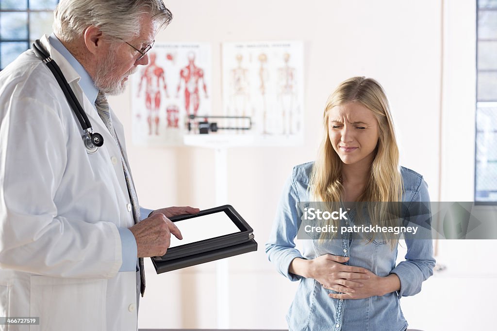 Descrivendo i sintomi al medico - Foto stock royalty-free di Mal di stomaco