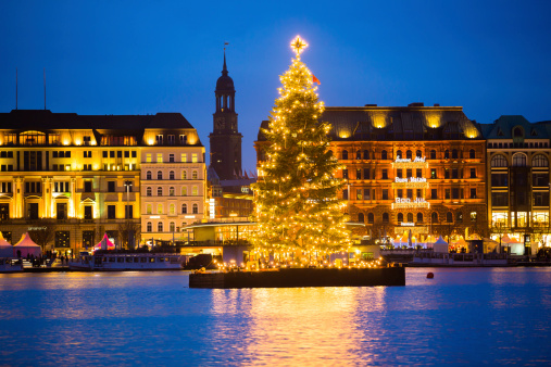 Lit up Christmas tree on the Asterlake harbor at night