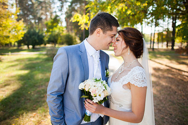istock happy bride, groom standing in green park 466736632