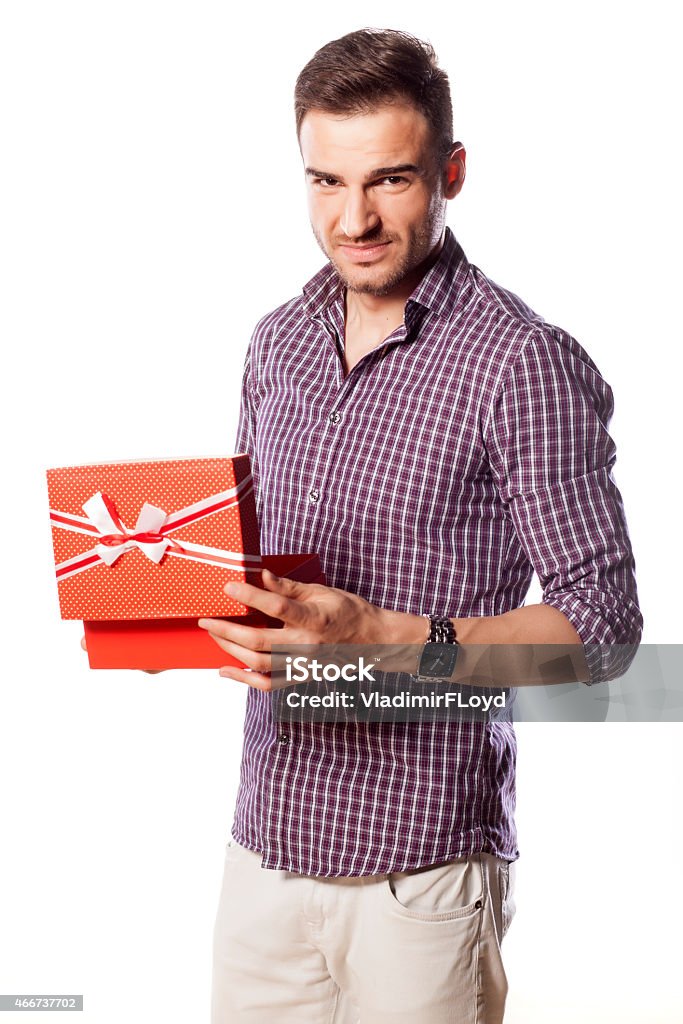 Unhappy young man poses with a gift in his hands unhappy young man poses with a gift in his hands 2015 Stock Photo