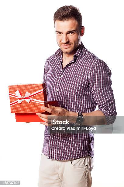 Unhappy Young Man Poses With A Gift In His Hands Stock Photo - Download Image Now - 2015, Adult, Adults Only