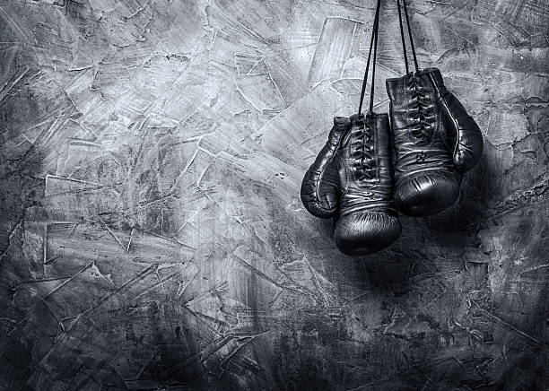 istock Old gray boxing gloves hanging up 466738284