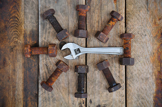 istock Old bolts with adjustable wrench tools on wooden background. 466738668