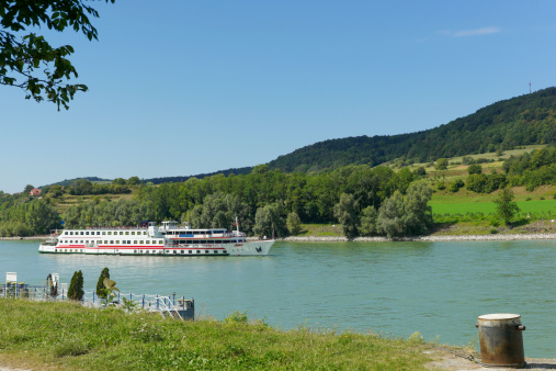 Tour boat  is cruising at danube river near melk city of austria