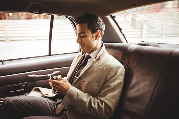 homme d'affaires sur un taxi jaune de sms - people traveling business travel travel new york city photos et images de collection