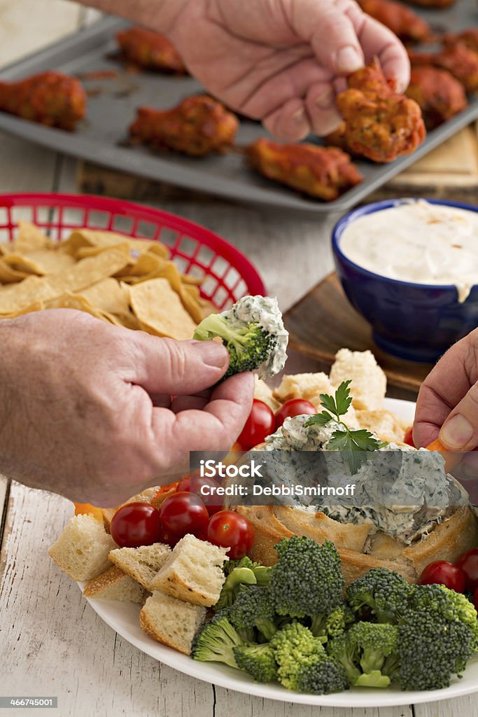 Time To Chow Down A close up shot of hands reaching out for championship game snacks. Food Stock Photo