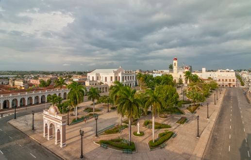 CIENFUEGOS, CUBA -  MAY 5: Aerial view to Jose Marti park with Arch of Triumph and Cathedral of the Immaculate Conception lit by evening sun under heavy clouds shown on 5 May 2008 in Cienfuegos, Cuba