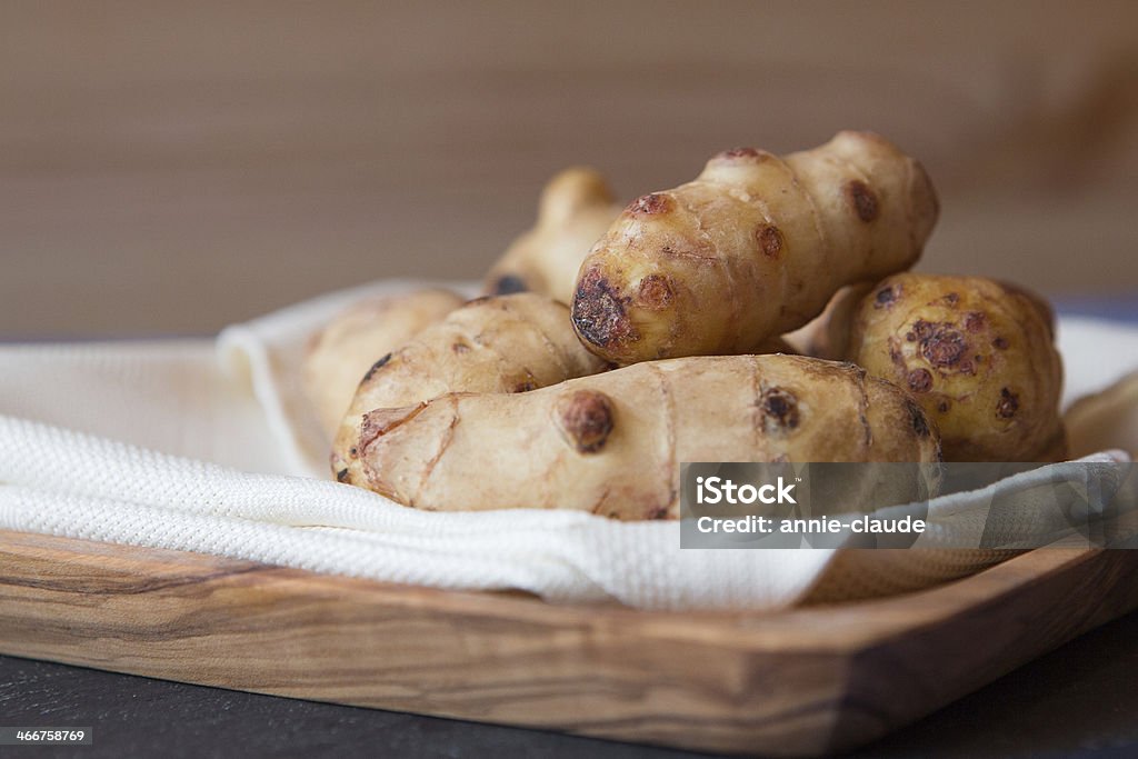 jerusalem artichokes Fresh raw jerusalem artichokes on a wood plate. Jerusalem Artichoke Stock Photo