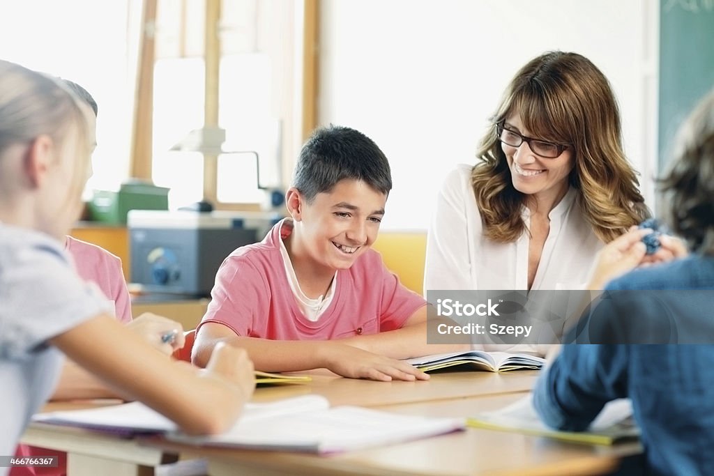 Teacher and student on a lesson. Teacher and student in a classroom at school. 60-69 Years Stock Photo