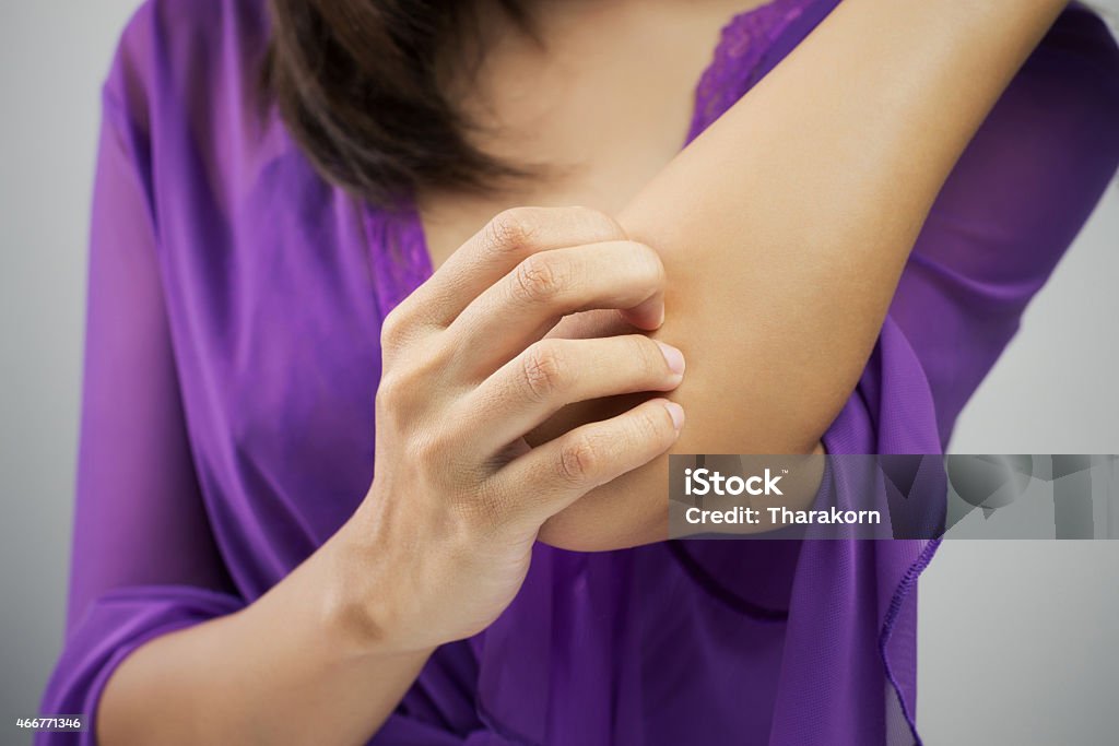 itching Woman scratching her arm Scratching Stock Photo