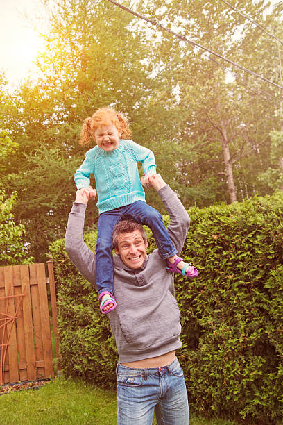 istock Unsure kid getting off dad's shoulders in suburban backyard. 466771503