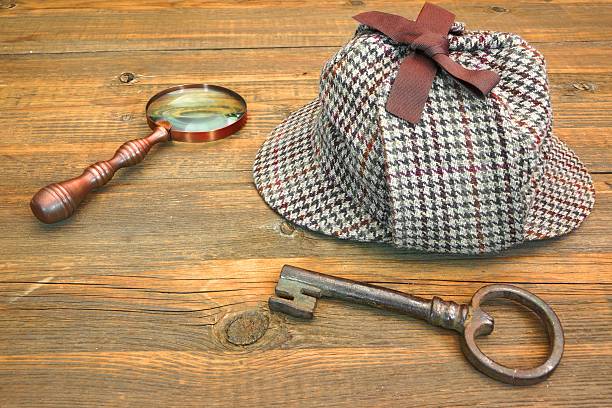 istock Deerstalker Hat, Old Key and Magnifier on Wooden Table 466772310