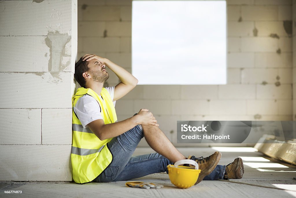 Male construction worker agonizes over accident at worksite Construction worker has an accident while working on new house Accidents and Disasters Stock Photo