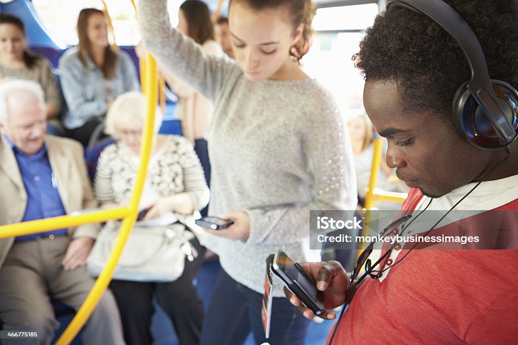 Passengers Using Mobile Devices On Bus Journey Passengers Using Mobile Devices On Bus Journey During The Day Public Transportation Stock Photo