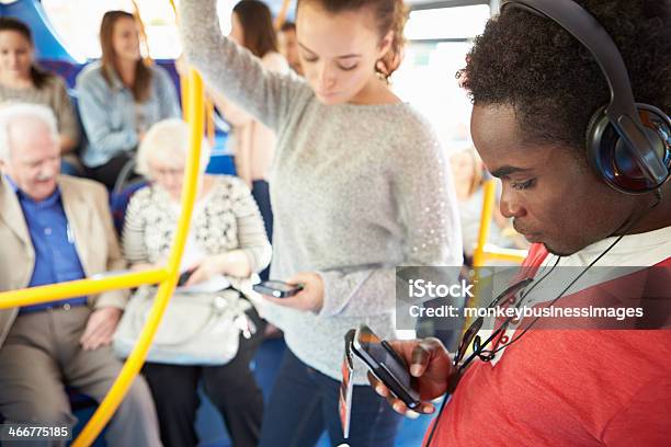 Passengers Using Mobile Devices On Bus Journey Stock Photo - Download Image Now - Public Transportation, Telephone, Women