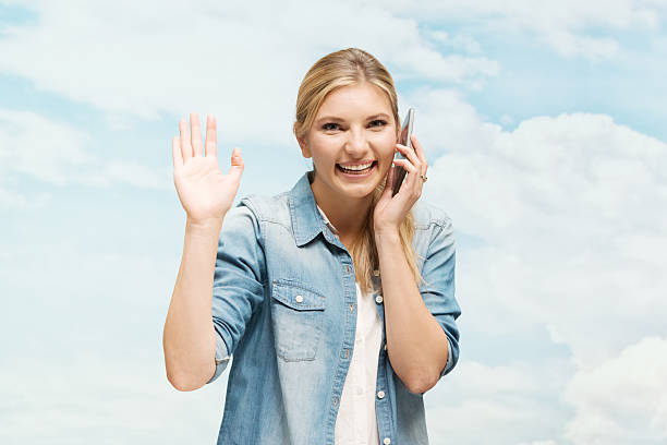 istock Smiling woman on mobile and waving hand 466775788