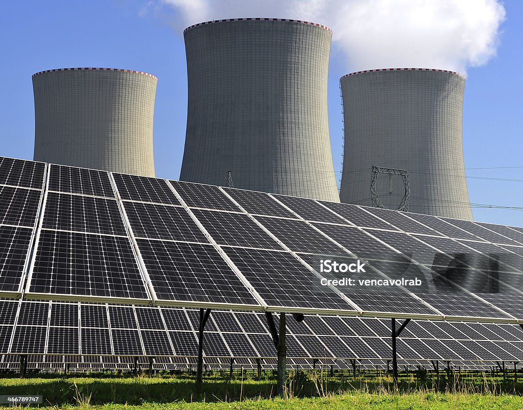 energy concept Solar energy panels before a nuclear power plant Danger Stock Photo