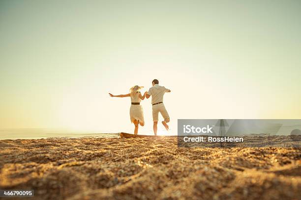 Couple Jumping To The Sea Stock Photo - Download Image Now - Couple - Relationship, Adult, Beach