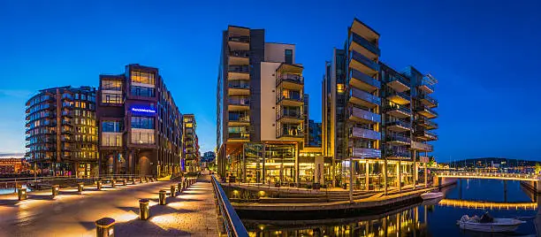 Modern waterfront apartment buildings with glass balconies overlooking the luxury residential and leisure district of Aker Brygge in central Oslo, Norway. ProPhoto RGB profile for maximum color fidelity and gamut.
