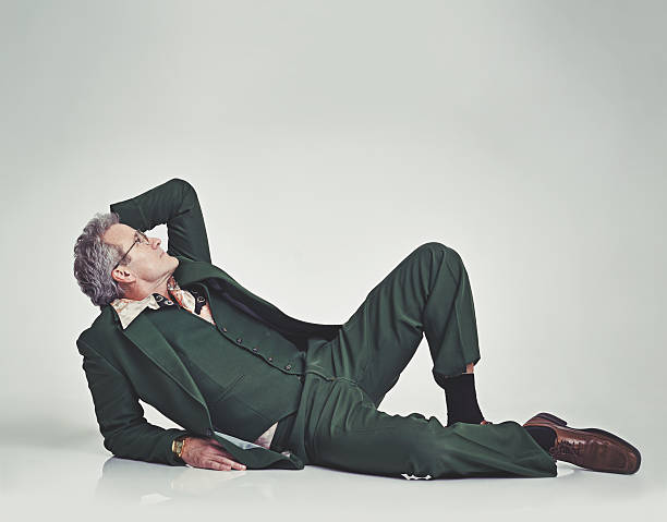 Studio shot of a mature man in a retro suit lying down and striking a posehttp://195.154.178.81/DATA/istock_collage/0/shoots/782690.jpg