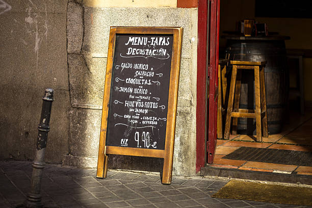 Tapas Menu in Madrid A chalkboard outside a Madrid restaurant offers a tasting menu of typical tapas dishes for a set price. bar stool photos stock pictures, royalty-free photos & images