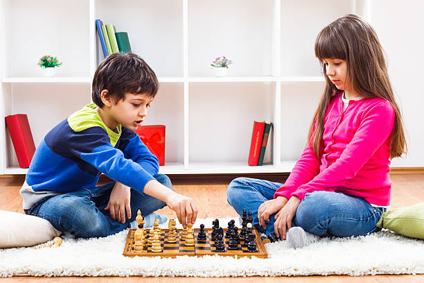 niños jugando al ajedrez - concentration chess playing playful fotografías e imágenes de stock