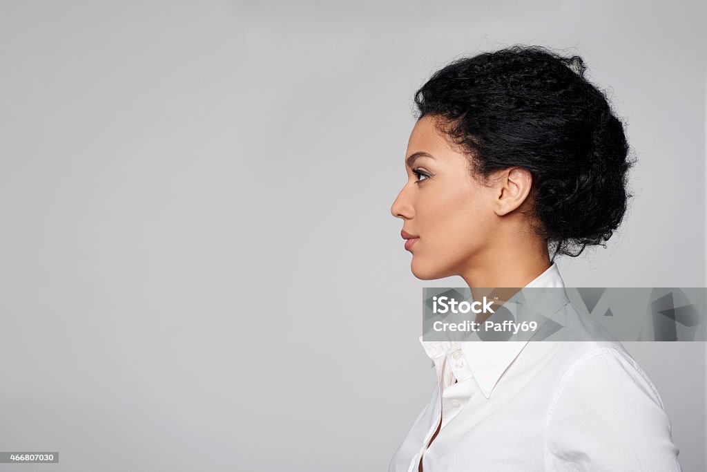 Closeup profile of business woman looking forward Closeup profile of confident business woman looking forward isolated on gray background Profile View Stock Photo