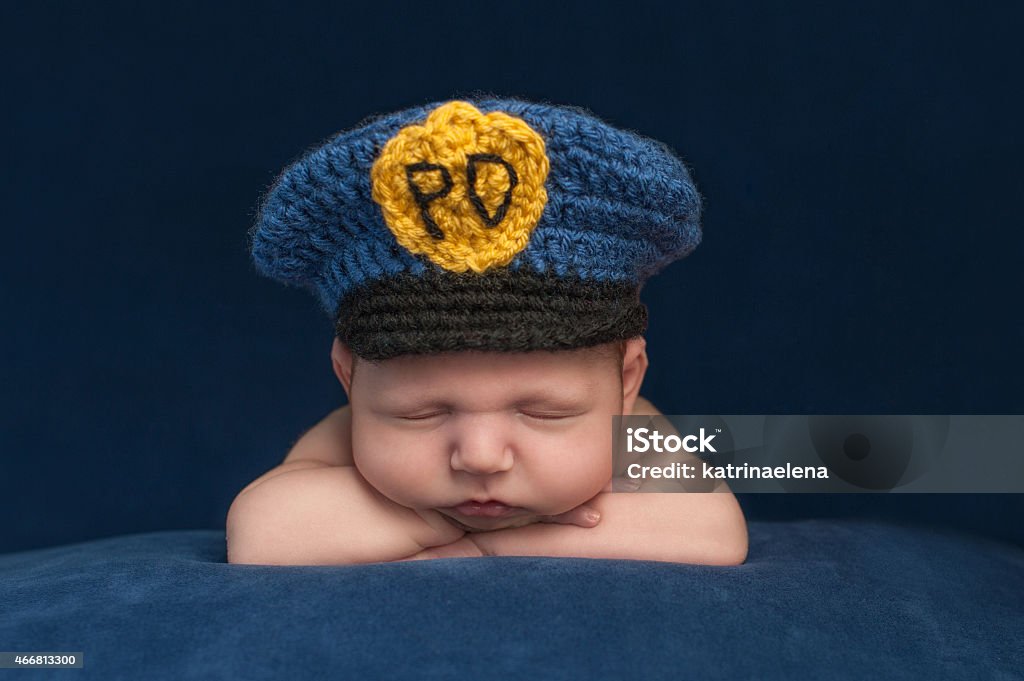 Newborn Baby Bloy Wearing a Police Hat Twelve day old sleeping newborn baby boy wearing a blue crocheted police officer hat. Police Force Stock Photo